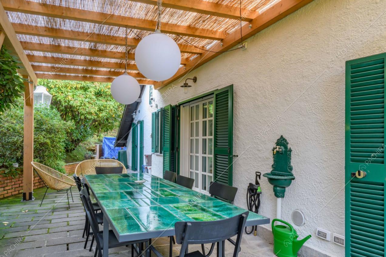 Veranda con tavolo dal piano da lavoro verde e sedie nere in metallo