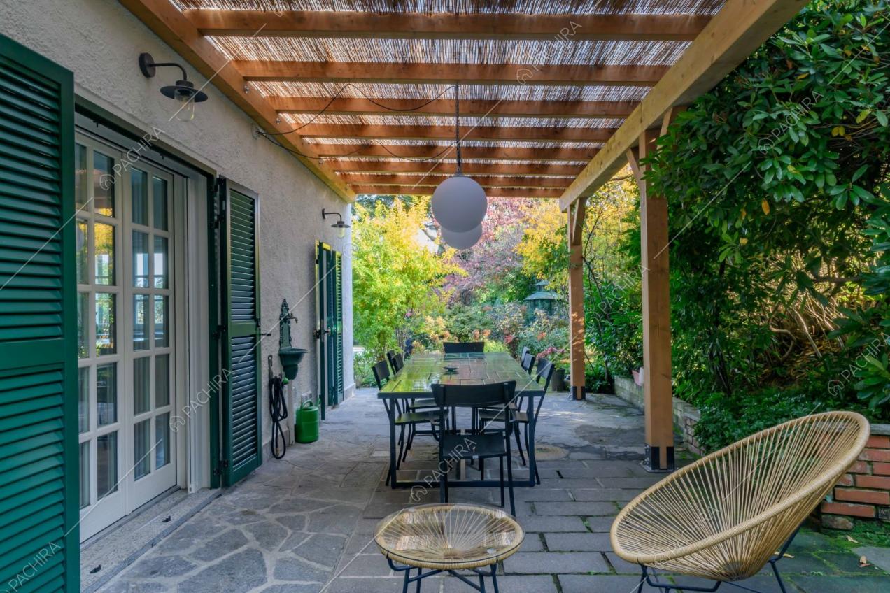 Veranda con sedie, tavolo da pranzo da esterni e pavimentazione in pietra