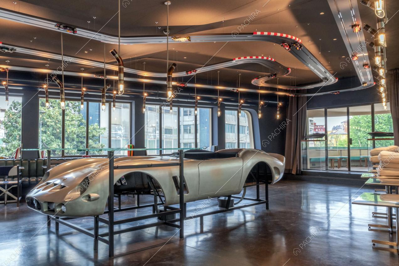 Telaio di un'automobile nella sala con grandi vetrate e pista per macchinine sul soffitto