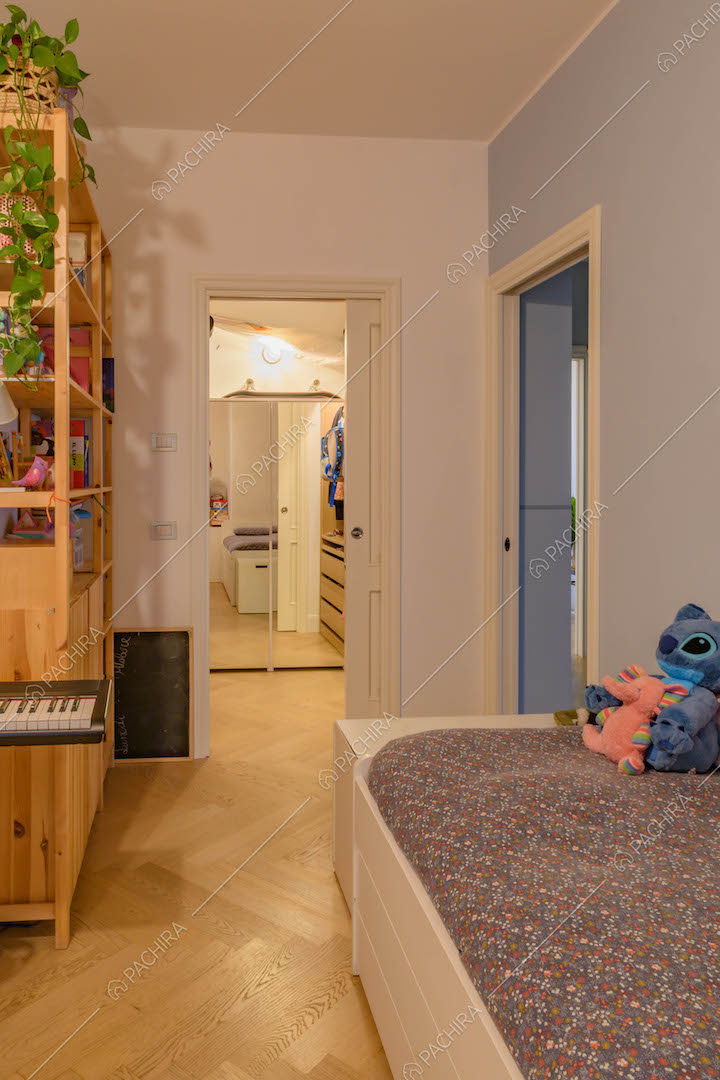 Camera da letto con pavimento in parquet a spina di pesce e cabina armadio