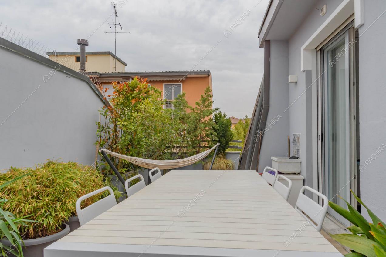 Terrazza con amaca, tavolo da pranzo e sedie bianche