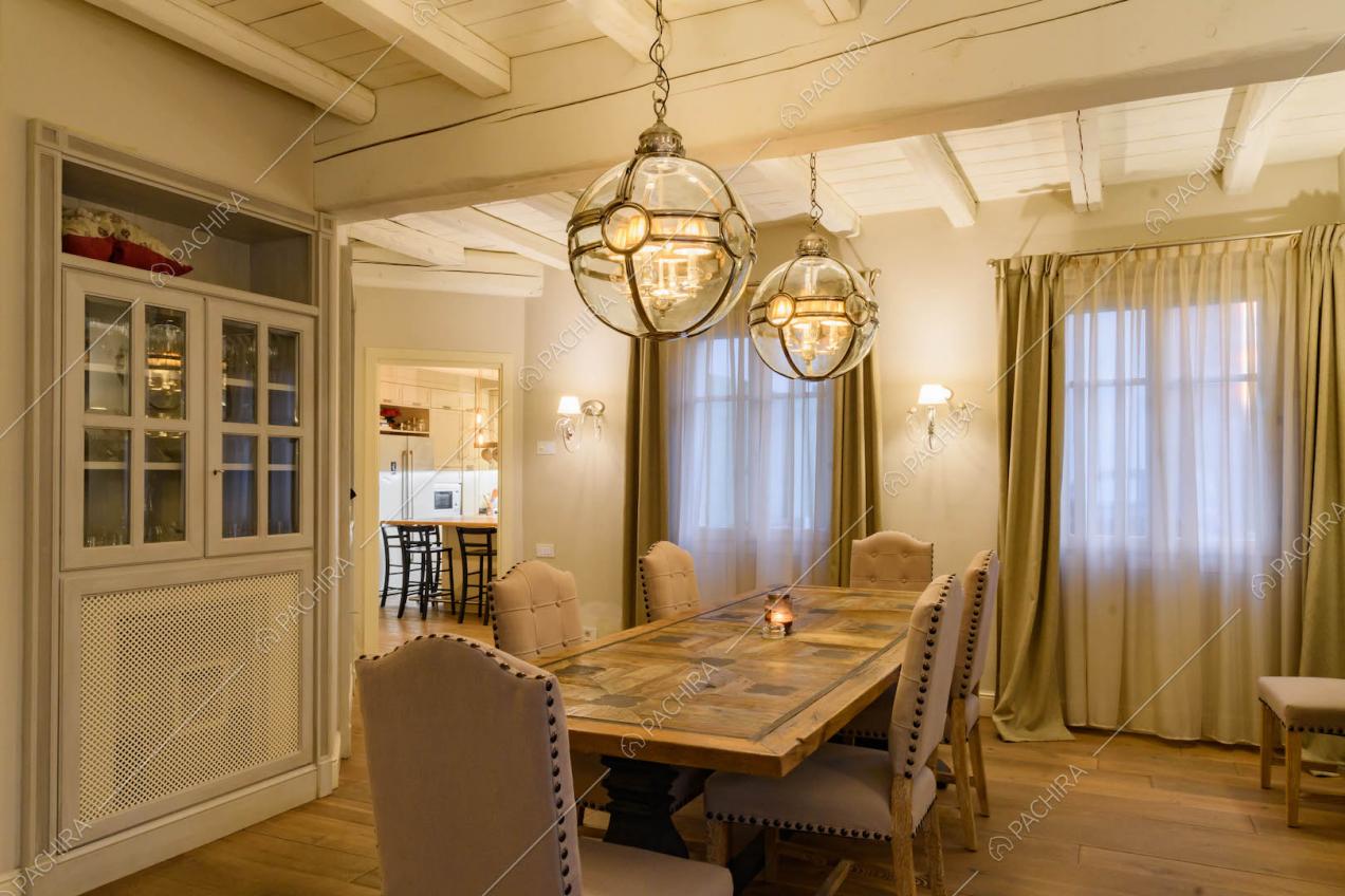 Tavolo da pranzo nella sala e scorcio sulla cucina a isola