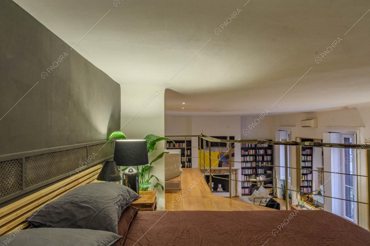 Letto matrimoniale sul soppalco con pavimento in parquet e vista sulla sala