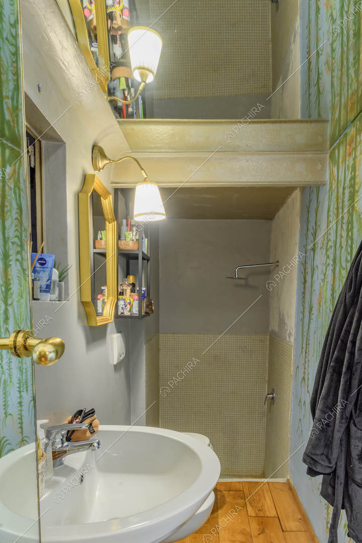Bagno con specchio sul soffitto, pavimento in parquet e box doccia