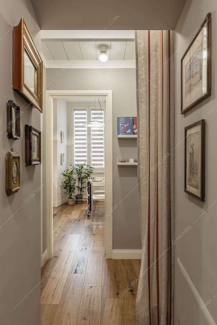 Corridoio dalle pareti grigie e dal pavimento in parquet