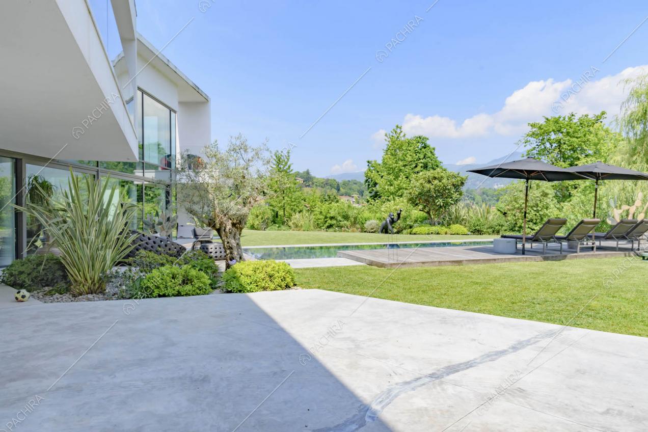 Nel giardino con piscina, pavimento in cemento e portico
