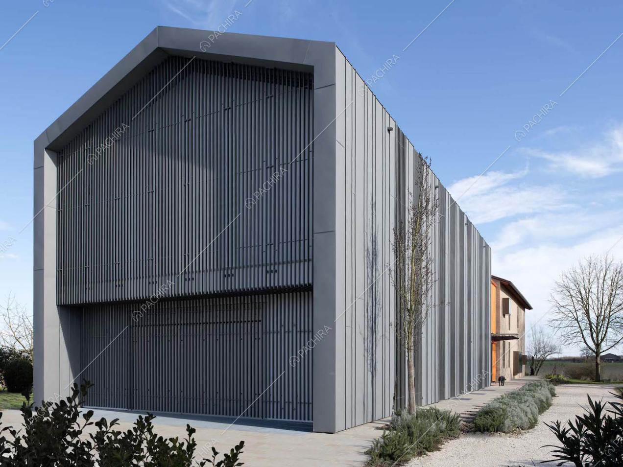 Esterni in stile industriale visti dal giardino della villa