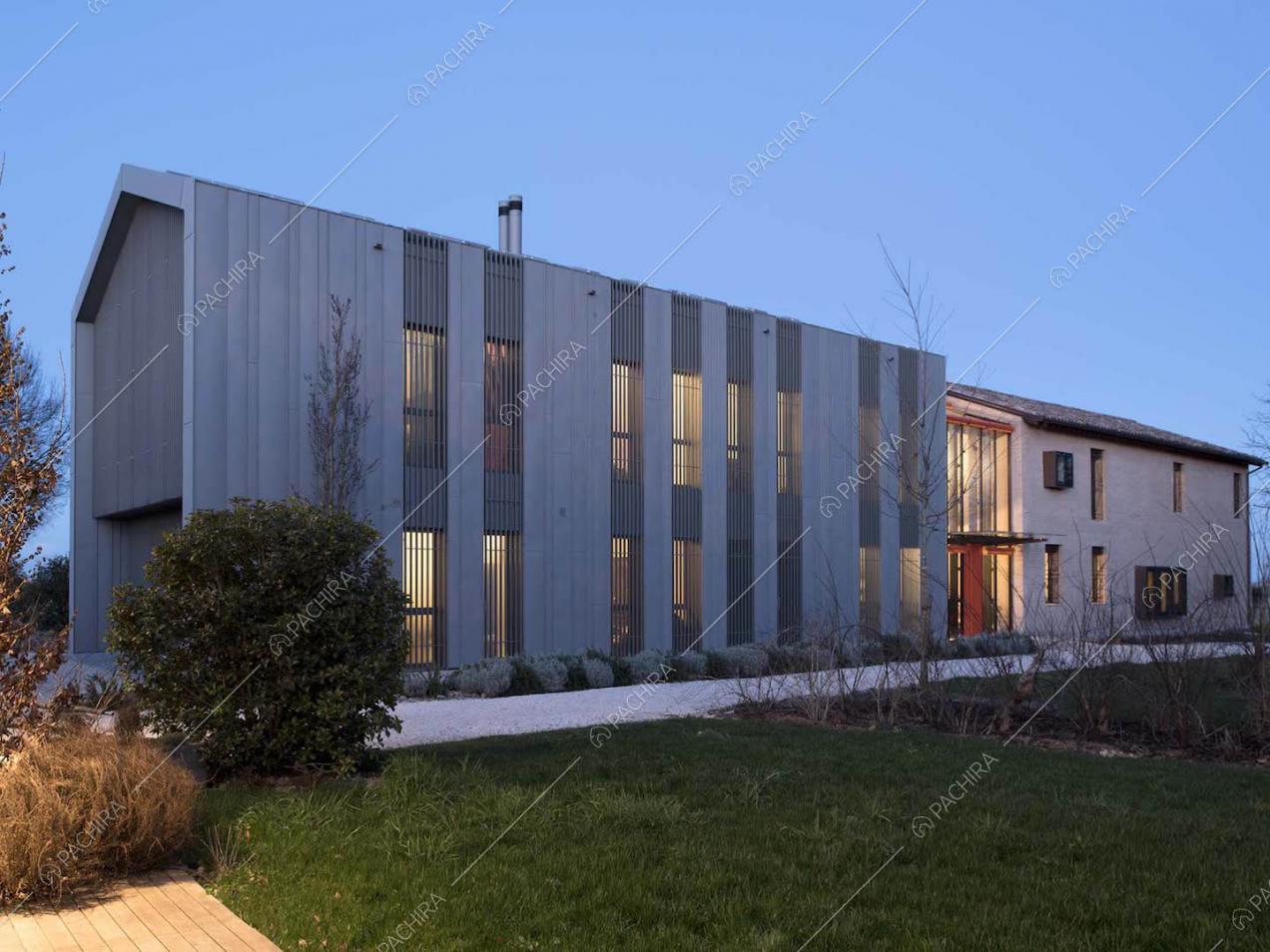 Esterni della villa in stile industriale e rustico visti dal grande giardino