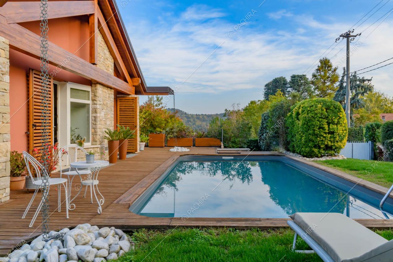 Giardino con piscina, pavimentazione in parquet e vista sui monti circostanti