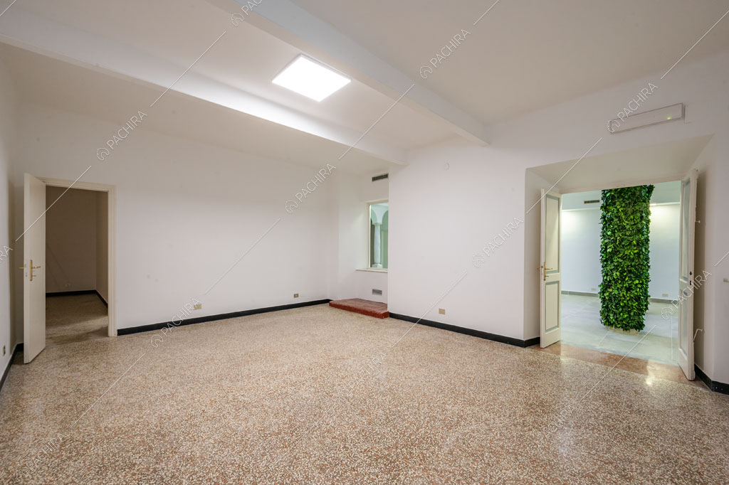 Ampio salone con pareti e soffitto bianchi e lucernario