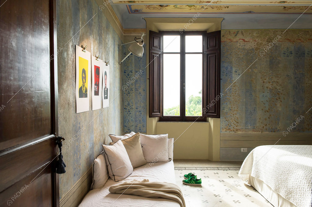 Pouf nella camera da letto matrimoniale con pareti délabré affrescate gialle e azzurre