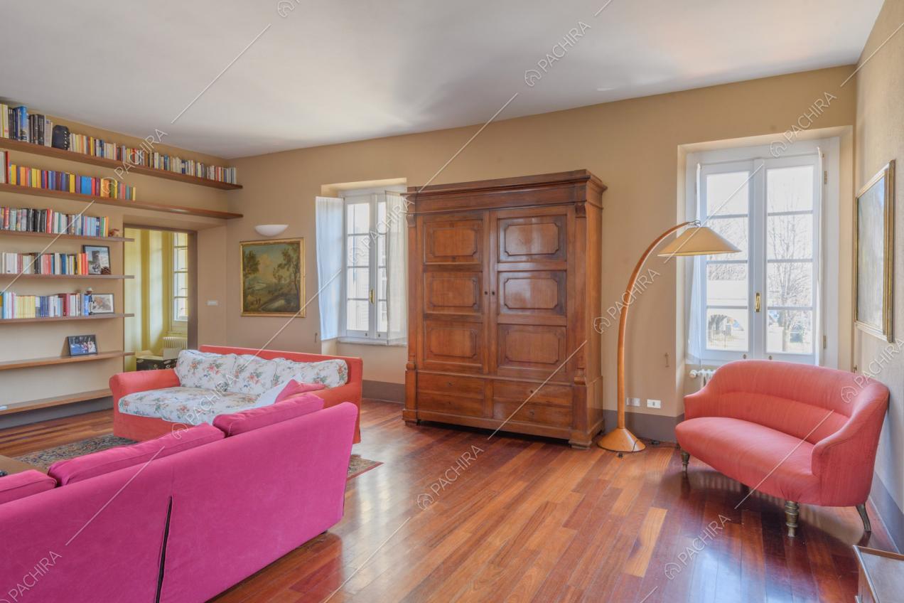 Pareti marrone chiaro e pavimento in parquet nella zona living con divani colorati