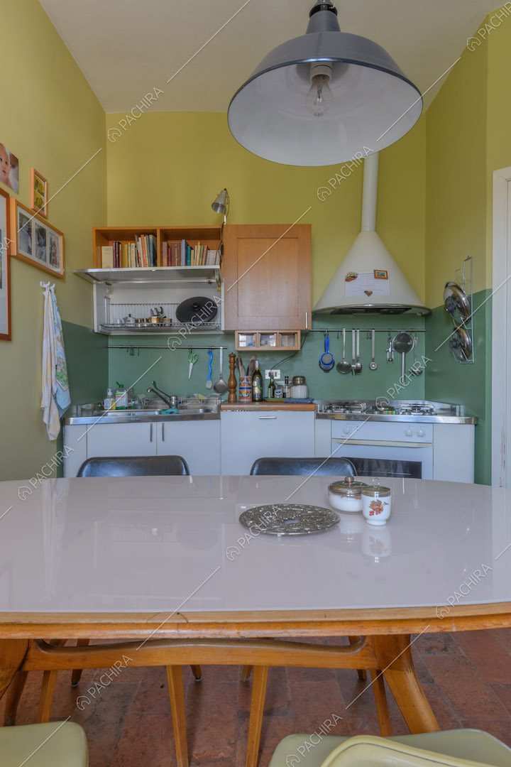 Tavolo bianco da pranzo nella cucina a parete gialla e verde