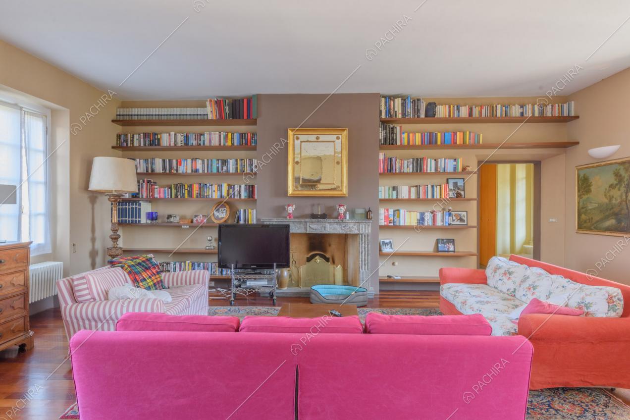 Divani colorati nel luminoso salotto dalle pareti marroni e con pavimento in parquet