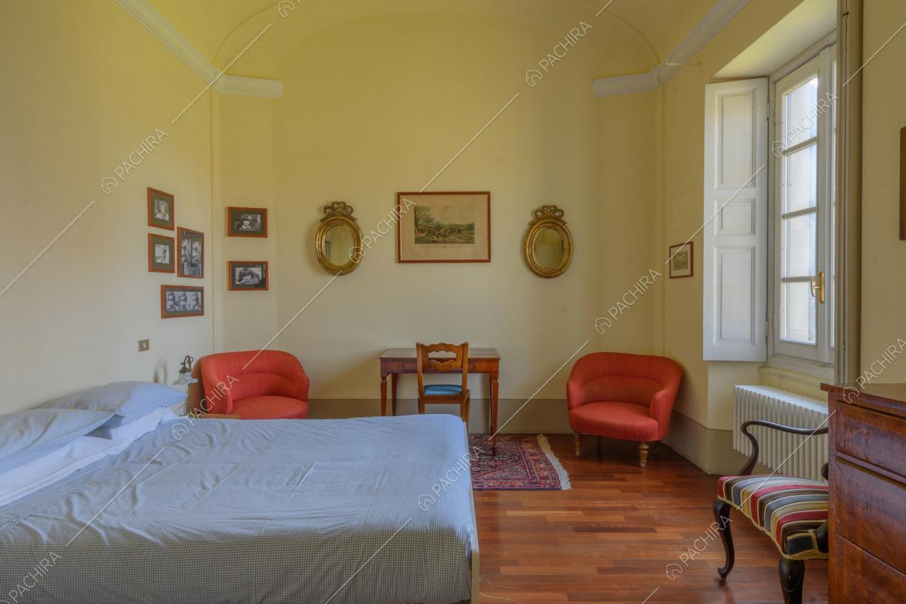 Grande camera da letto matrimoniale con pavimento in parquet e pareti gialle