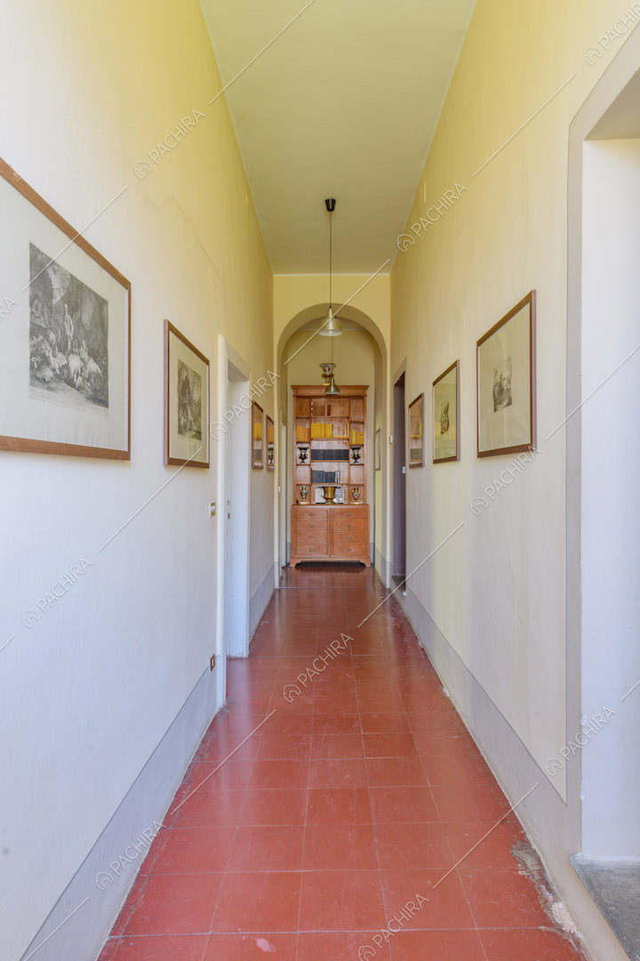 Luminoso corridoio con pareti bianche e pavimento in piastrelle rosse