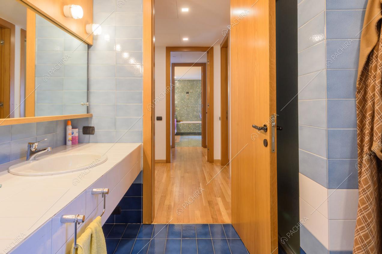 Doppio lavandino nel bagno con pareti e pavimento in piastrelle blu