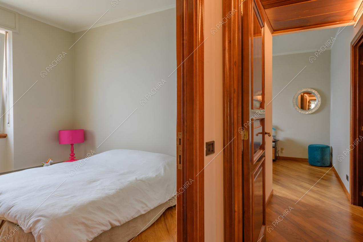 Camera da letto dalle pareti beige e con pavimento in parquet