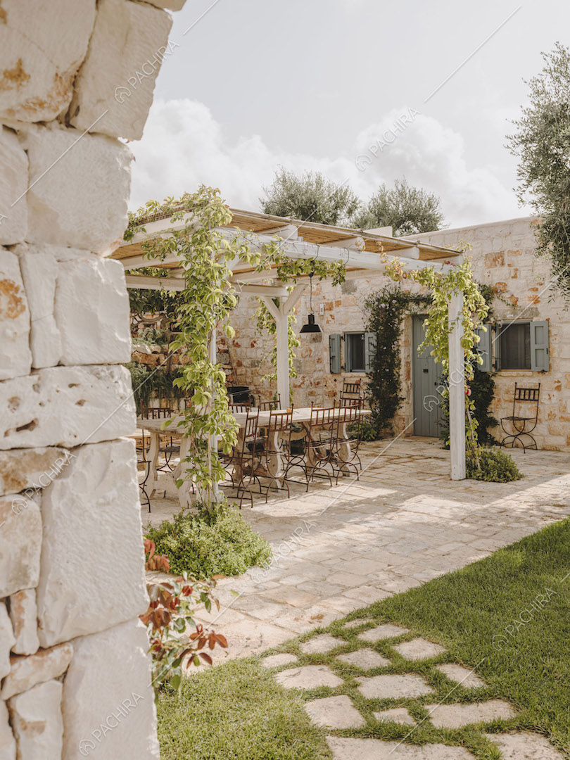 Dal vialetto in lastre in pietra vista sul patio con tavolo da pranzo