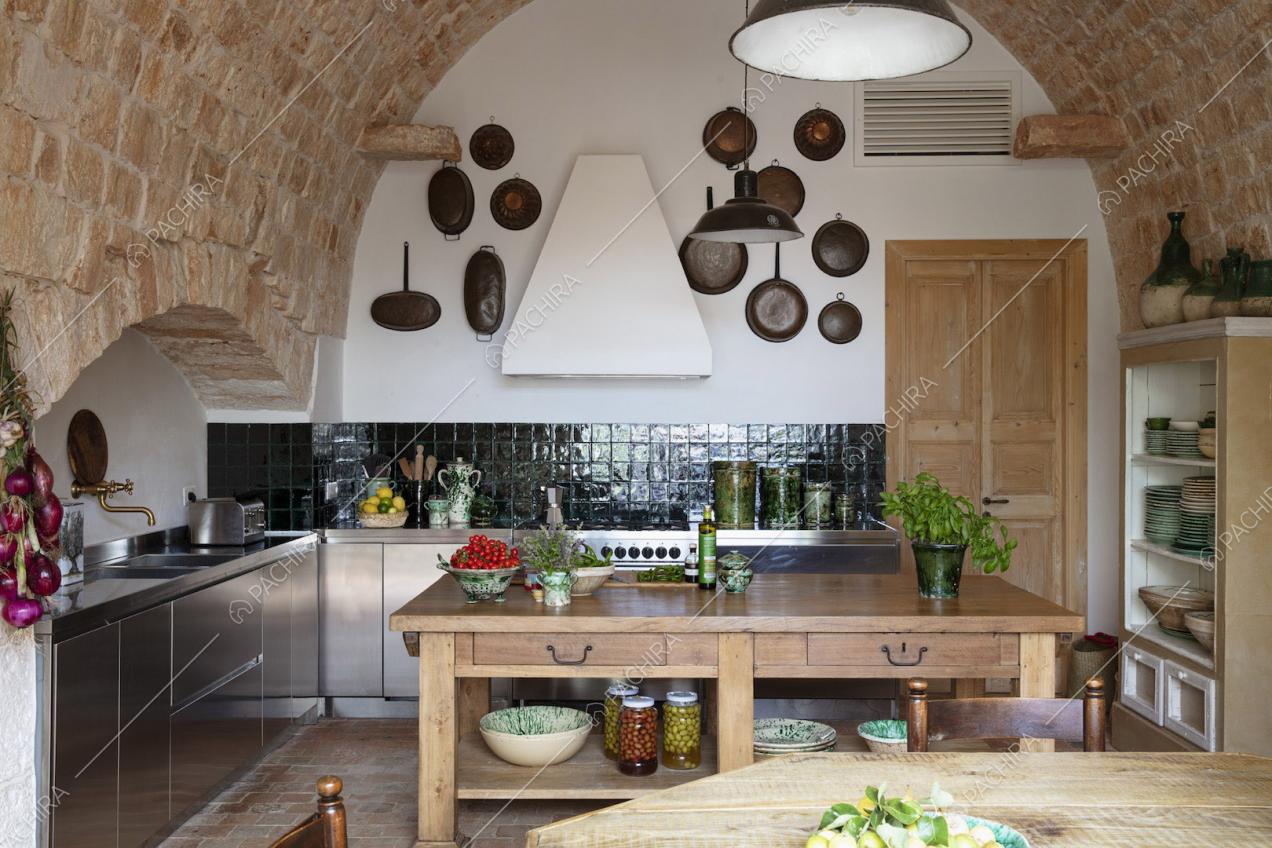 Cucina a parete in acciaio con soffitto a volta dai mattoncini rossi