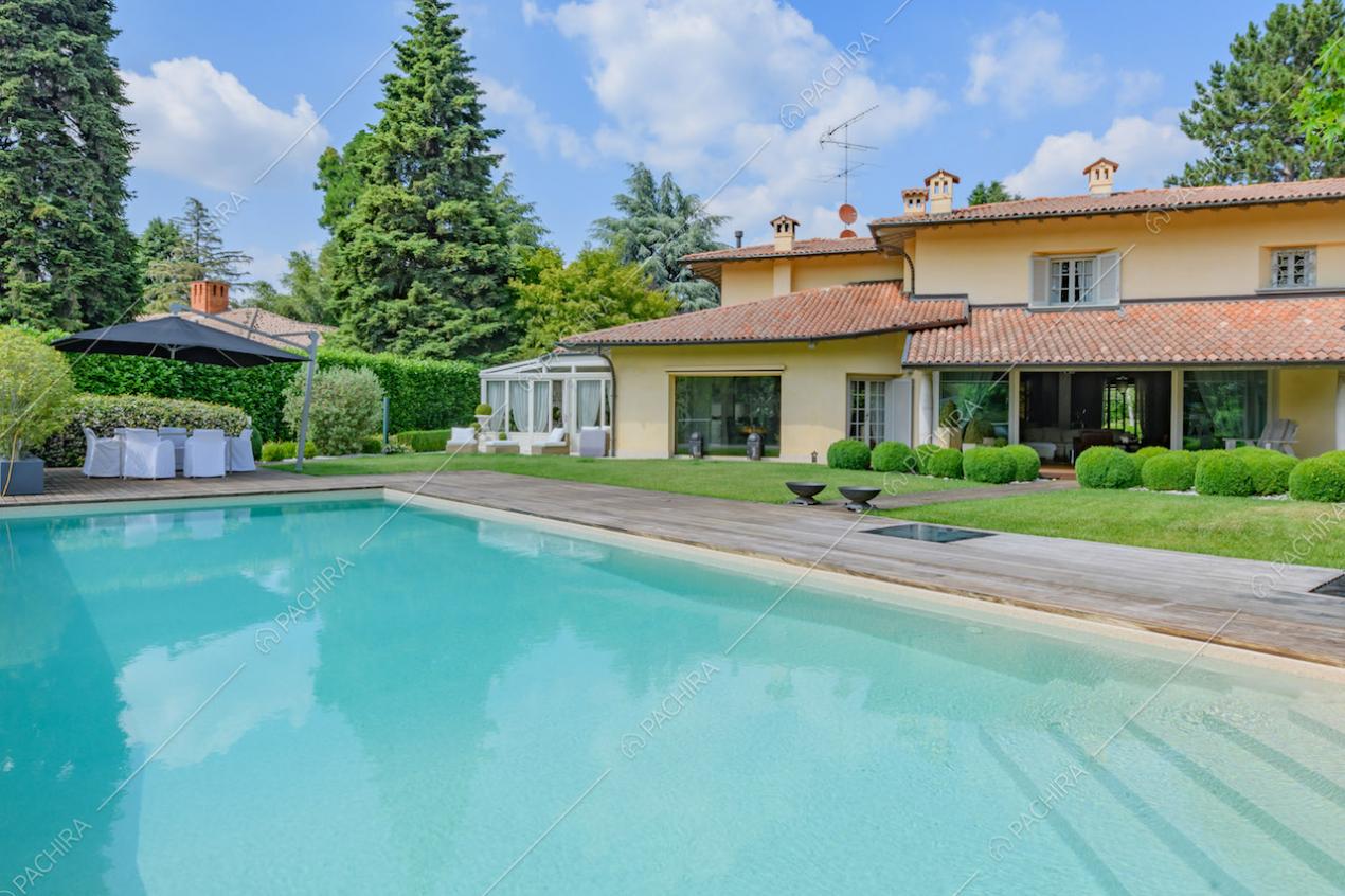 Grande piscina nel giardino della villa con vista sulla veranda