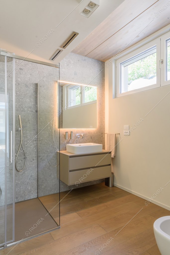Bagno con box doccia, specchio retroilluminato e pavimento in parquet
