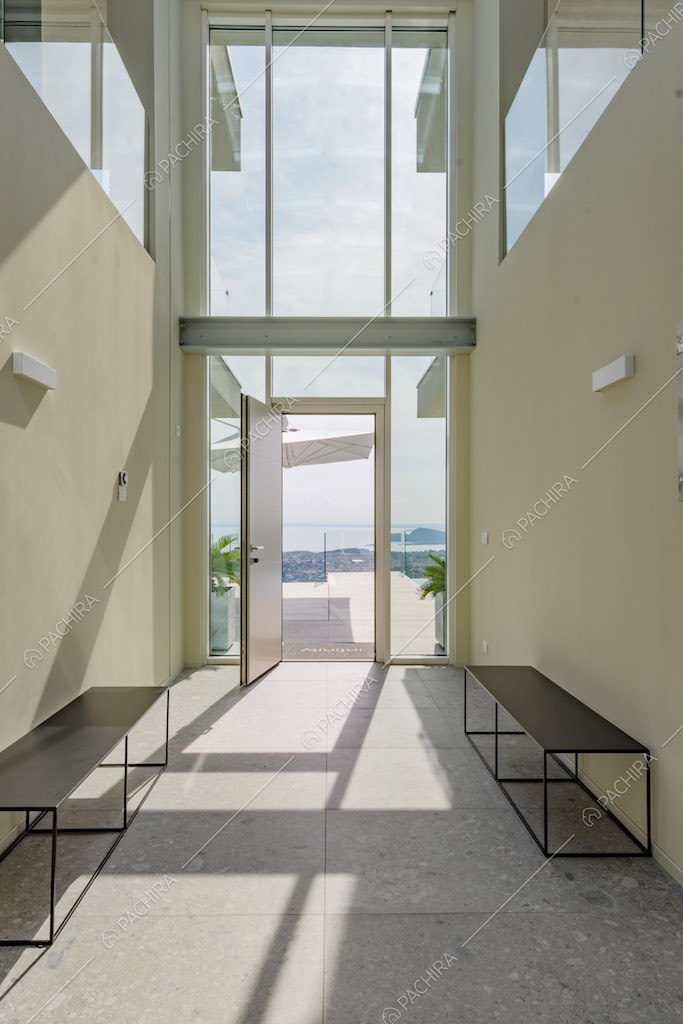 Corridoio con vetrata a tutta parete, vista sul lago e alto soffitto