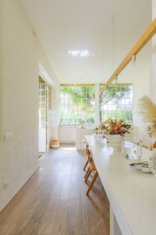 Pavimento in parquet nella grande sala con tavolo da pranzo bianco