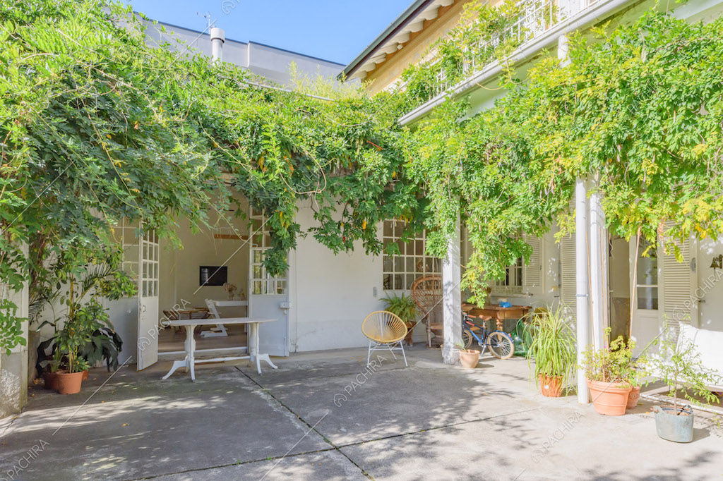 Giardino con portico, piante rampicanti e scorcio sulla zona living
