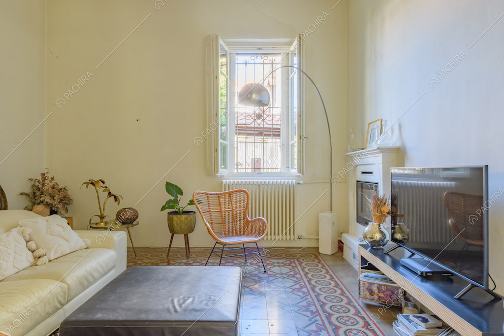 Divano in pelle bianca e pavimento in piastrelle a fantasia geometrica nel salotto