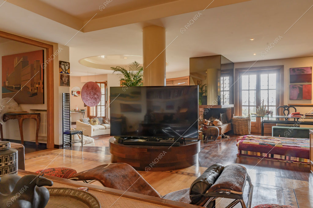 Poltrona di design con vista sulla sala con divano bianco rotondo e camino