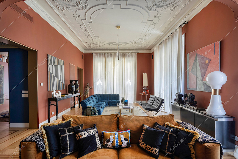 Divano marrone nella zona living con boiserie sul soffitto e grandi vetrate