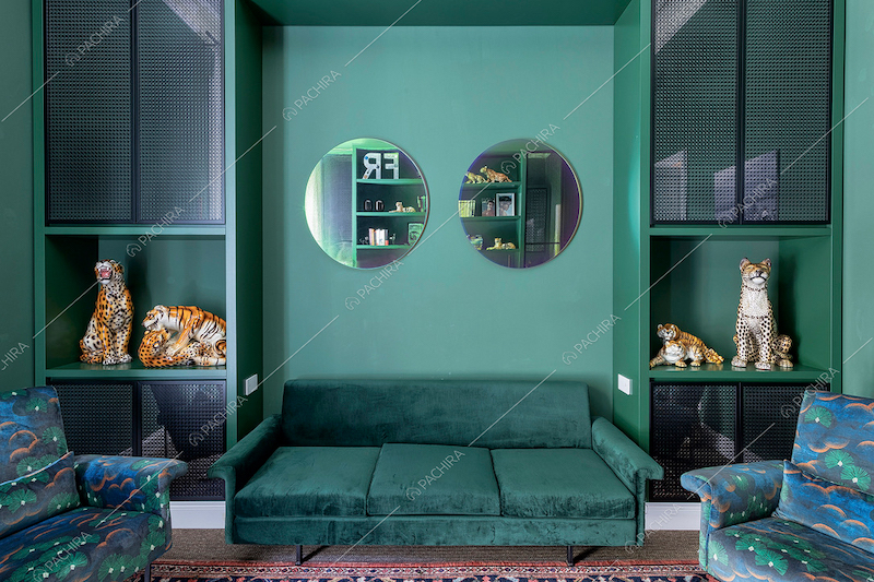 Divanetto in velluto nello studio verde con mobili di design