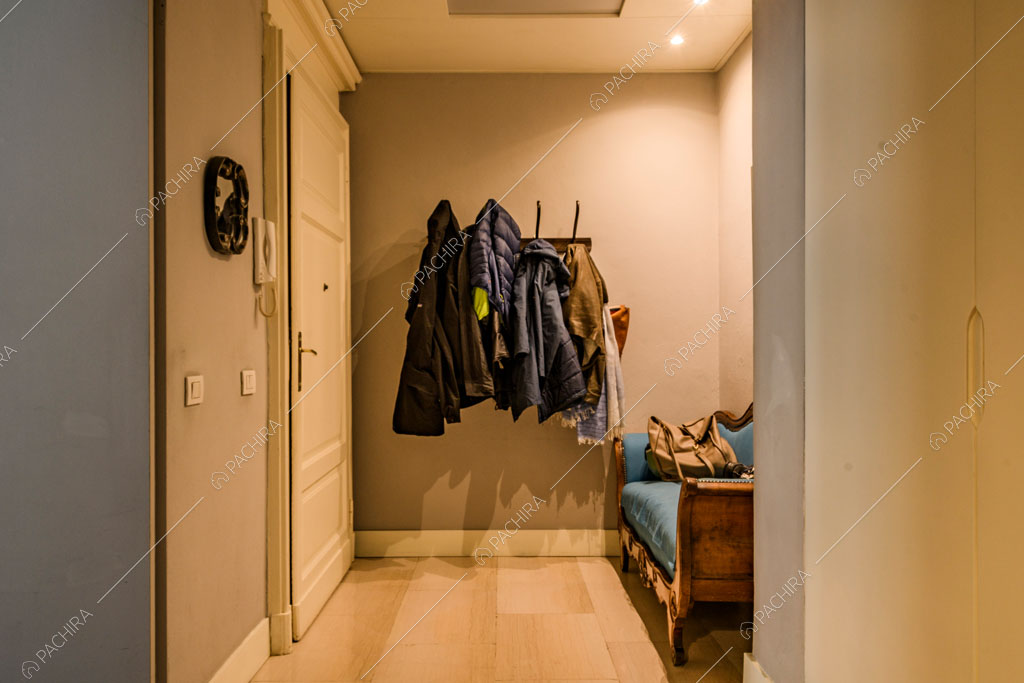 Ingresso con pavimento in parquet e divanetto antico blu