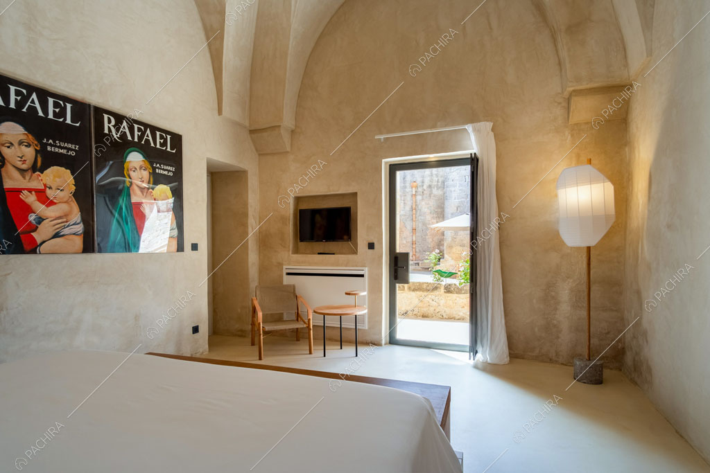 Camera da letto matrimoniale con poster e porta-finestra con vista sul giardino