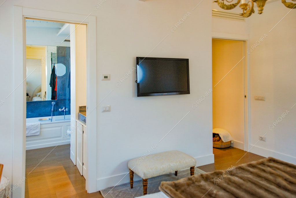 Camera da letto matrimoniale con pareti bianche e vista sul bagno privato