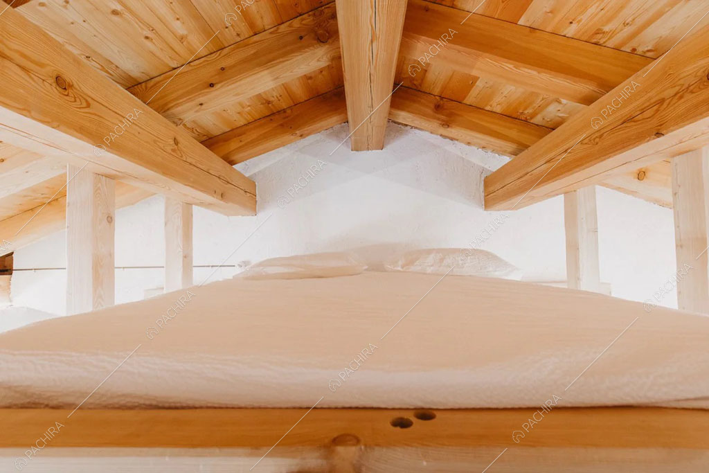 Letto matrimoniale sul soppalco dello chalet Timor, location in stile rustico a Trento