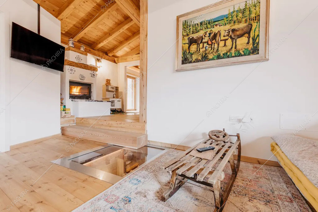 Salotto con pavimento in parquet dello chalet Timor, location in stile rustico a Trento