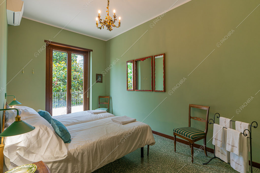 Camera da letto con pareti verdi della villa Ramaria, location in stile classico a Ravenna