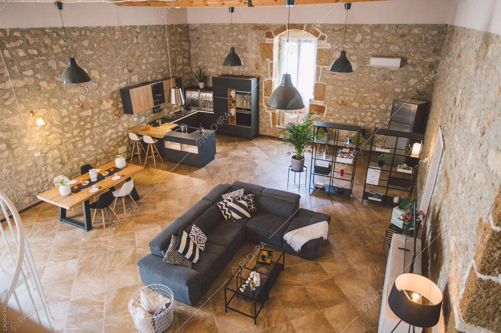 Pareti in pietra a vista della sala della villa Hibiki, location in stile moderno a Siracusa