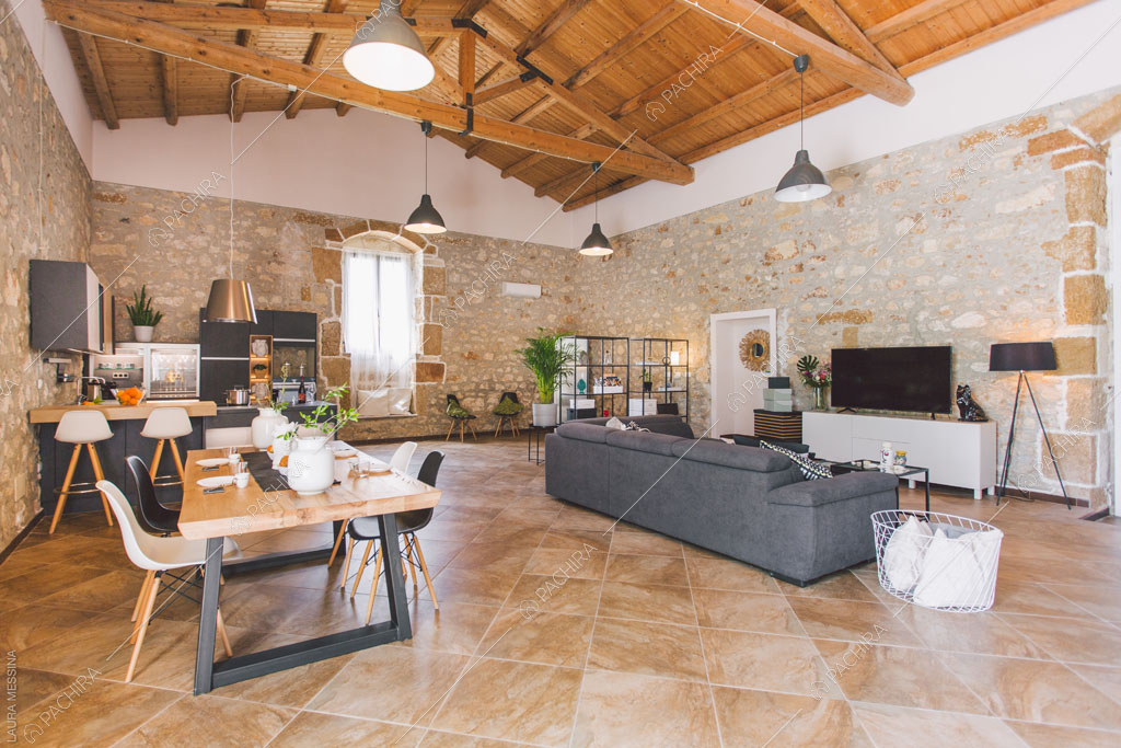 Travi in legno a vista sul soffitto della zona living della villa Hibiki, location in stile moderno a Siracusa