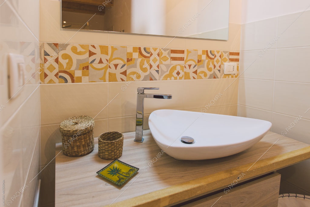 Bagno con piastrelle beige della villa Hibiki, location in stile moderno a Siracusa