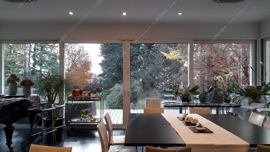 Zona living con grandi vetrate della villa Chalbi, location in stile moderno a Torino