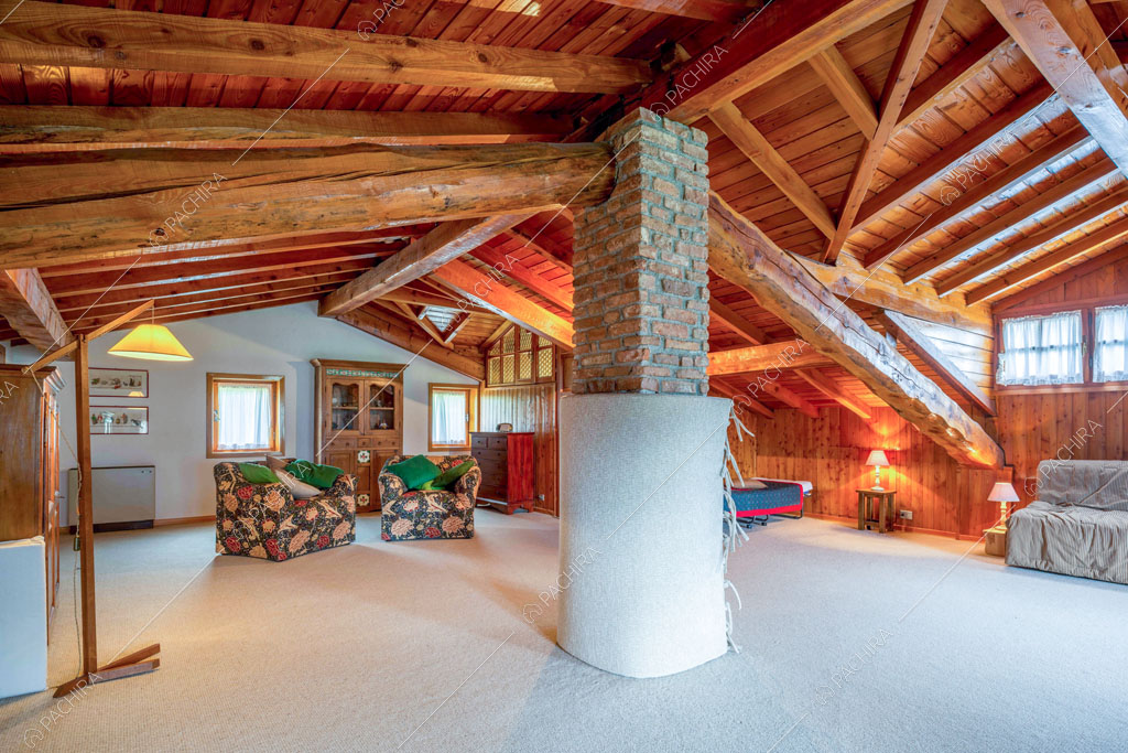 Sala con travi in legno a vista sul soffitto dello chalet Betel, location in stile rustico a Lecco