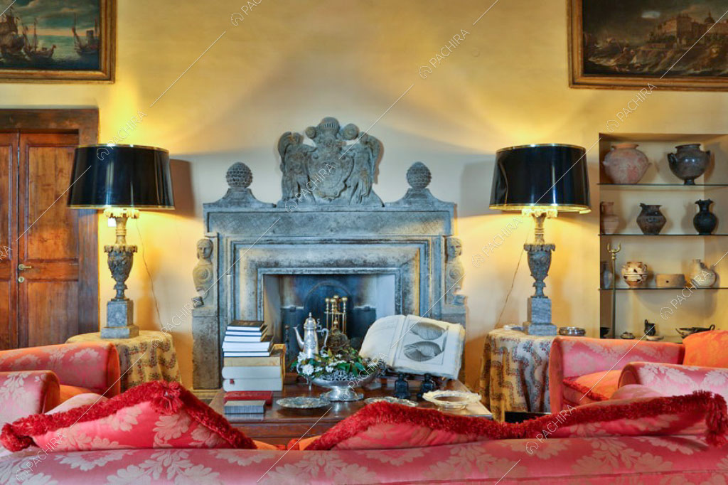 Camino nella sala con pareti gialle della villa Pieris, location in stile rustico a Roma