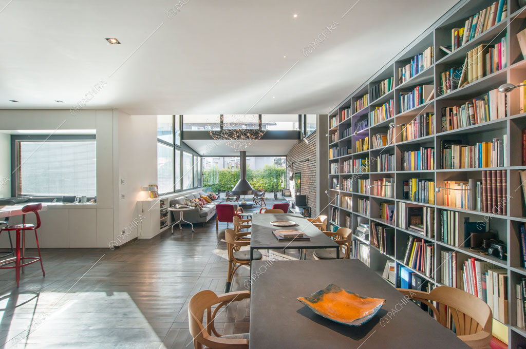 Zona living con pavimento in parquet e librerie dell'attico Karite, location in stile contemporaneo a Roma