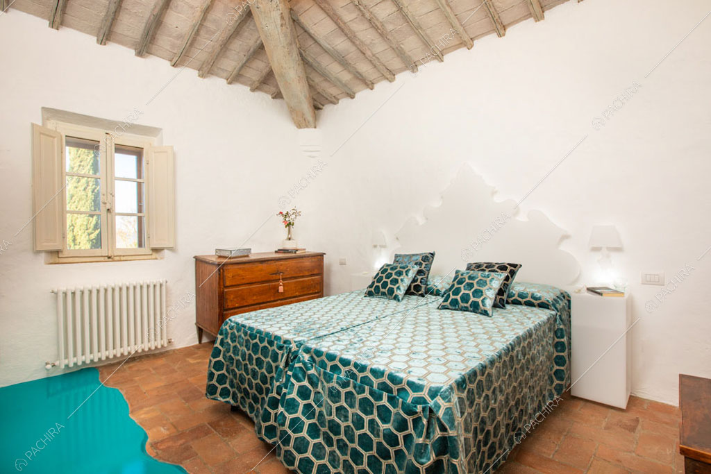 Camera da letto con pavimento in cotto della villa Bardenas, location in stile rustico a Siena