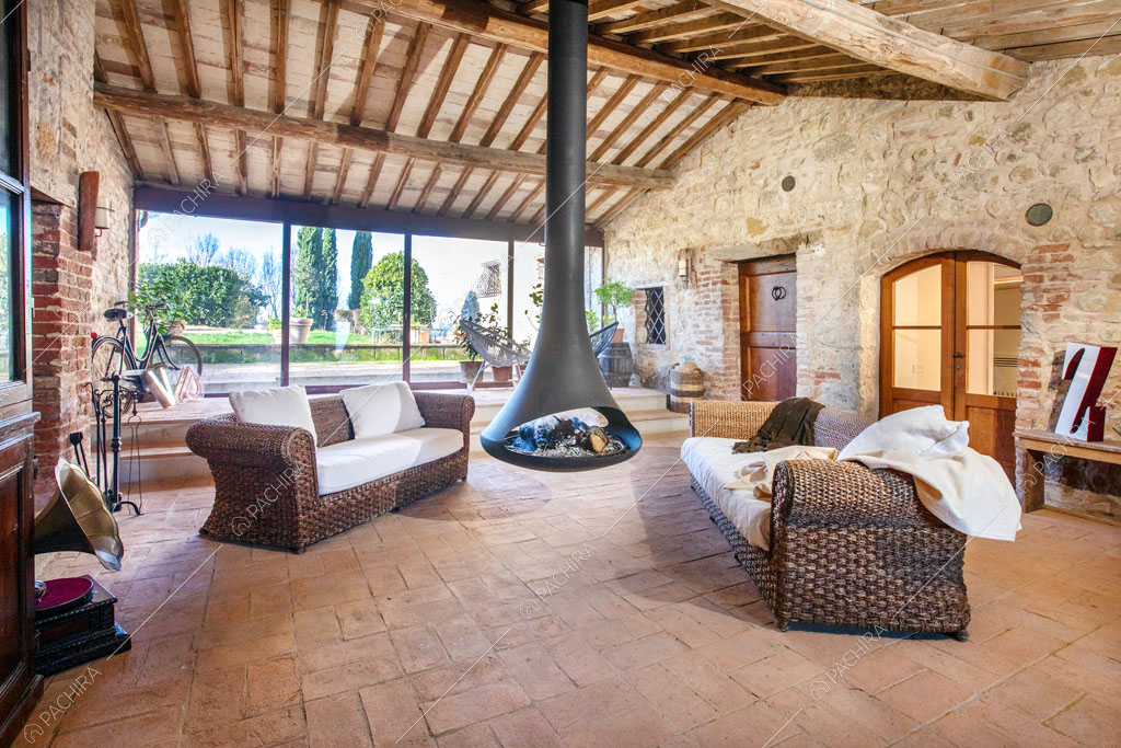 Pareti in pietra a vista nel luminoso salotto della villa Bardenas, location in stile rustico a Siena
