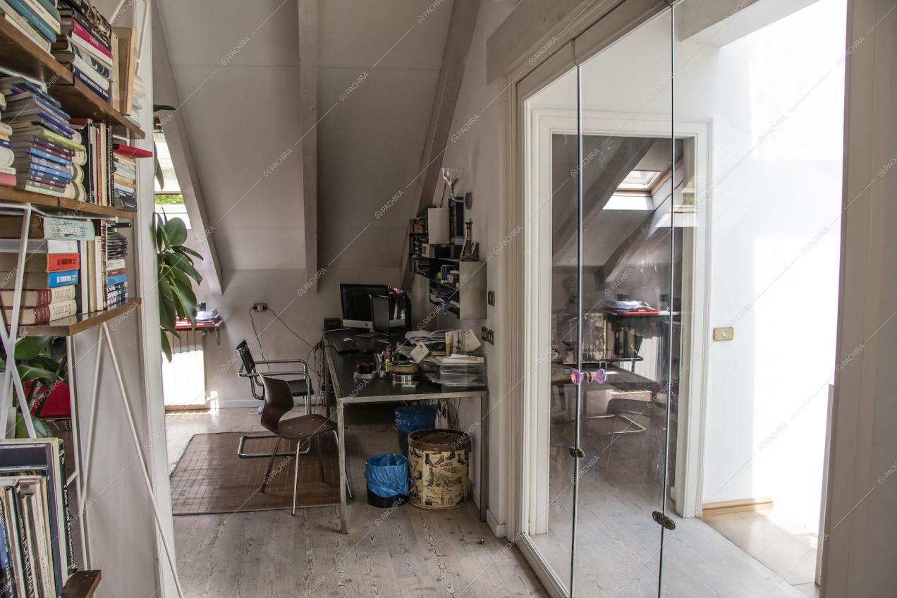 Scrivania nello studio con soffito in travi in legno a vista e pavimento in parquet