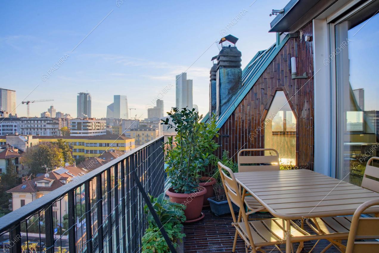 Terrazza con vista sullo skyline, tavolo e sedie da esterni e pavimento in piastrelle